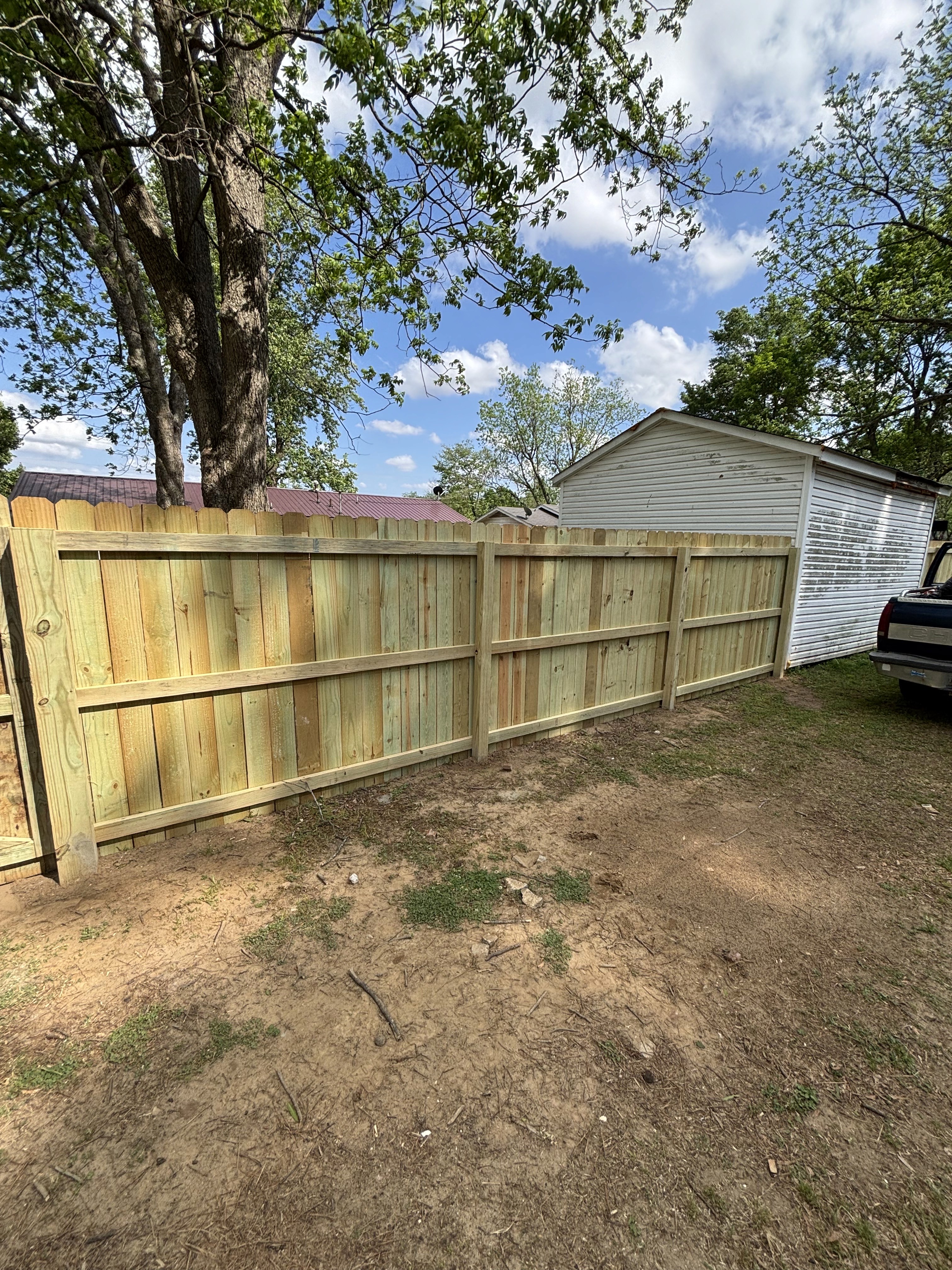 Cornerstone Fence and Deck owner in front of a completed wood privacy fence